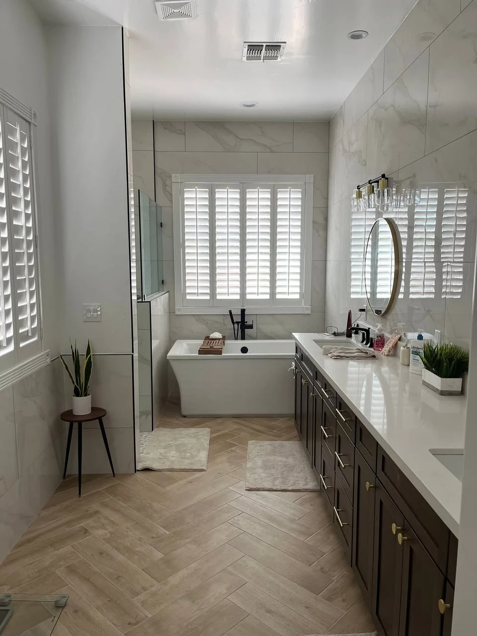 LOTI Peoria bathroom remodel with large-format wall tile, a freestanding tub, and warm herringbone tile flooring